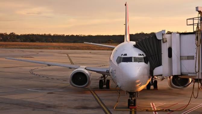 Airplane parked in an airport, showcasing tourist attractions in the Melbourne travel destination guide. 