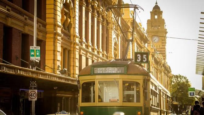 Tram in traffic, showcasing tourist attractions in the Melbourne travel destination guide. 