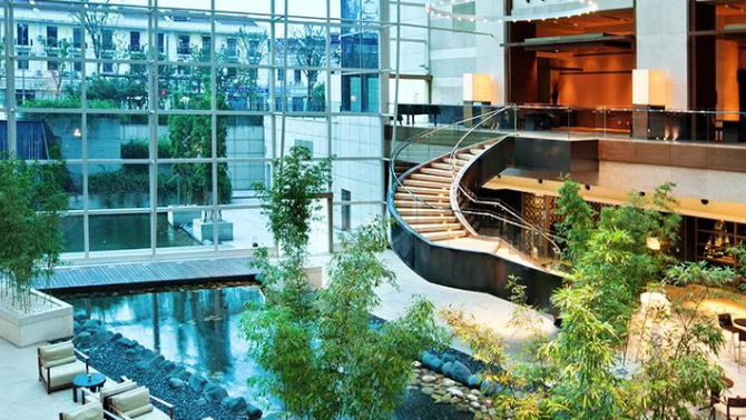 Hotel lobby and glass facade of a hotel demonstrating the transformation of high-end hotel lobbies into ‘micro-communities’ is becoming a popular trend in the hotel sector.