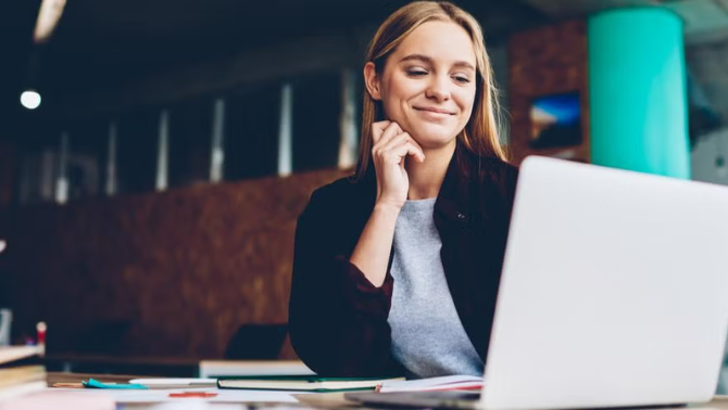 Woman looking at a laptop screen representing the importance of planning your personal and professional development