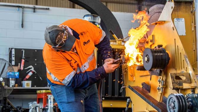 Man working on a farming machinery representing how RDO Equipment’s travel needs were met by the right TMC. 