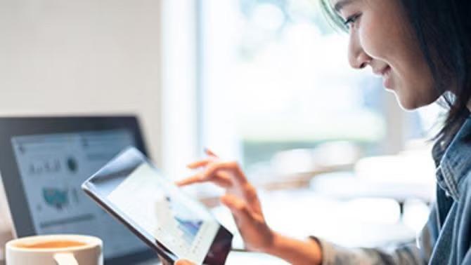 Woman working with a coffee representing use of technology in business travel.
