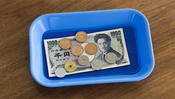 Japanese Yen in a bowl representing Tokyo destination travel guide.
