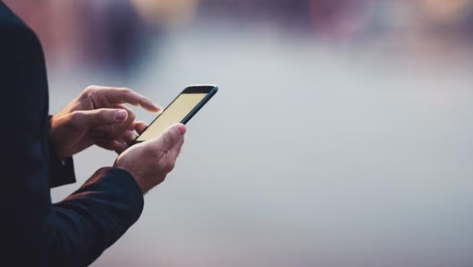 Hands holding a smartphone  representing the best apps for travel preparation.