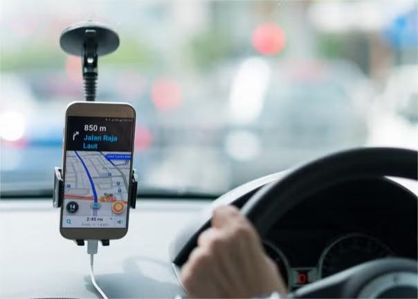 The front view of a car with the Uber app representing the sharing economy trend.