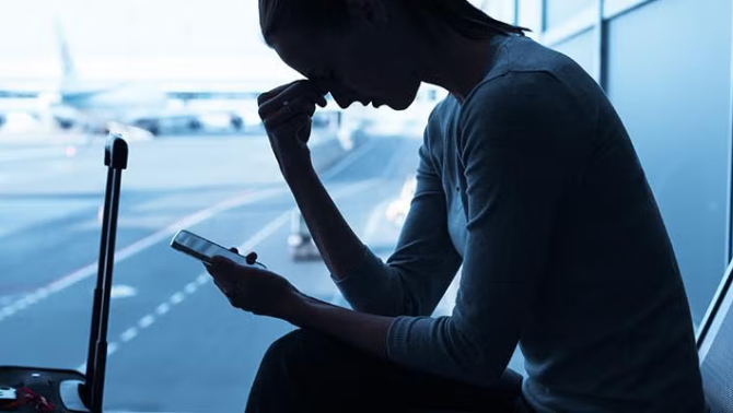 Woman sitting in the airport looking stressed representing Virgin Australia's new Nervous Flyer Program.