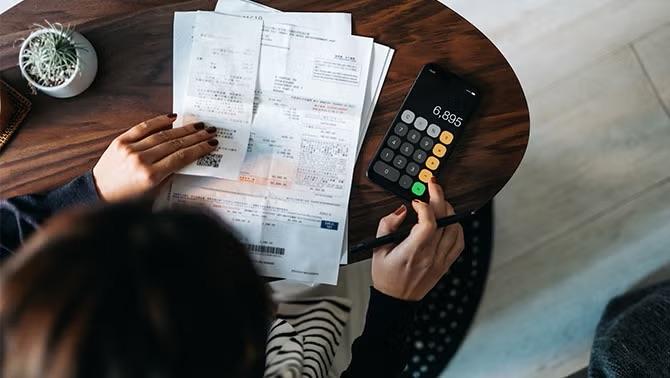Woman doing paperwork and calculations, highlighting bleisure travel and managing bleisure travel claims.