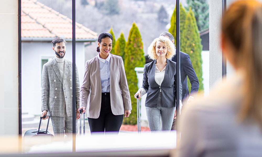 Co-workers walking towards a door representing how Customer Success Teams mission is to help your organisation create a best in market travel program.