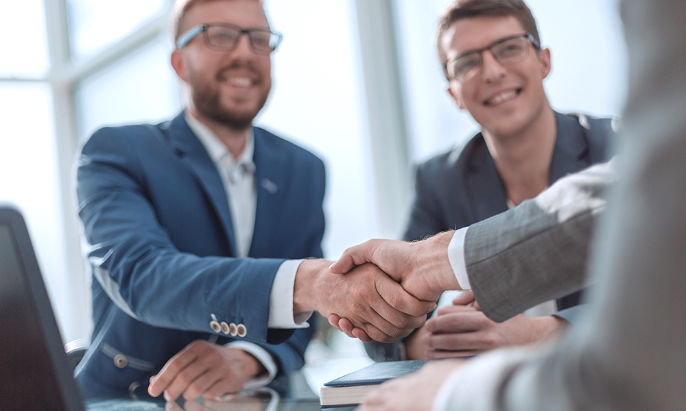 People shaking hands representing how Customer Success Teams mission is to help your organisation create a best in market travel program.