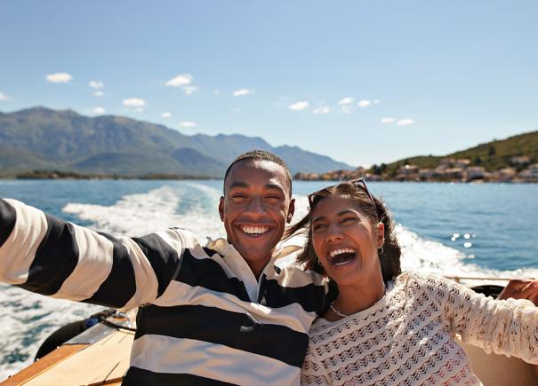 Man and woman smiling while taking a selfie on a boat.