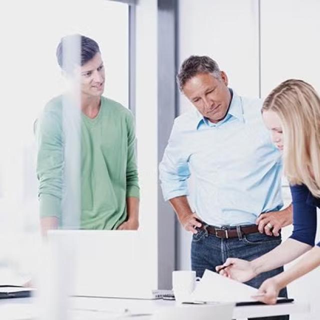 Three co-workers in discussion representing the importance of employee engagement in change management. 