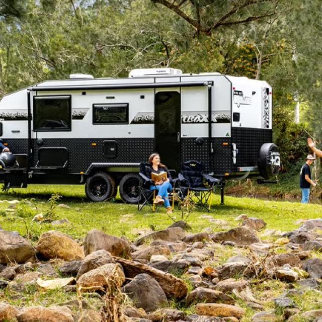 Family playing in a field with a caravan in the background representing how CHQ Group gained financial and logistical control by switching to Corporate Traveller.