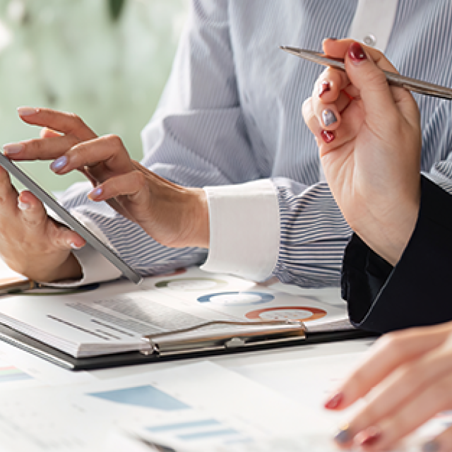 Co-workers reviewing a document representing how Corporate Traveller delivers technology and expense solutions that allow you to manage your travel, get vital information about your travel patterns and stay in control of your travel expenses.